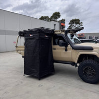 Bull Proof blackout shower tent deployed on the side of a Toyota LandCruiser 79 Series with a rooftop tent